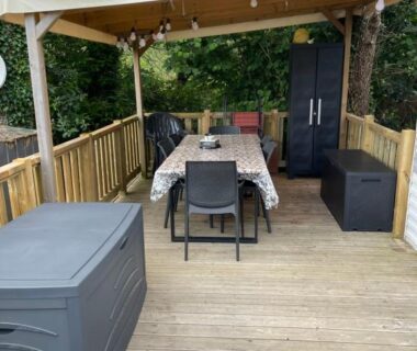 Terrasse en bois avec table à manger et pergola du Mobil home camping Paradis du Quinquis