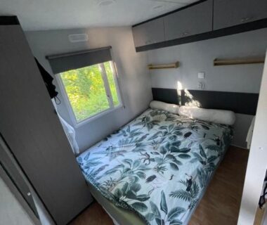 Chambre avec lit double et fenêtre dans le mobil home Paradis du Quinquis