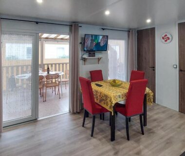 Séjour lumineux avec table et baies vitrées du Mobil-home camping etoiles Les Dunes de Contis Landes Fun pass compris