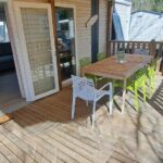 Terrasse en bois avec table chaises et coin cuisine du mobil home camping les Oyats