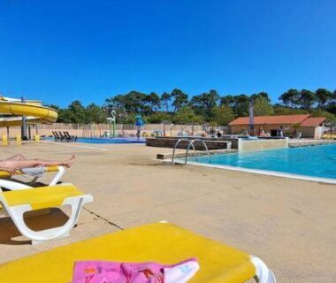 Bord de piscine avec transats et parasols au Mobil home camping les Oyats