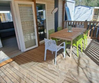 Terrasse en bois avec table chaises et coin cuisine du mobil home camping les Oyats