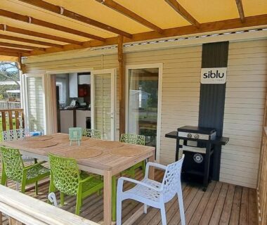 Terrasse couverte avec table chaises et barbecue du Mobil home camping les Oyats