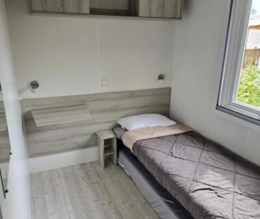 Chambre avec lit simple et fenêtre dans le mobil home camping les Viviers 8 personnes