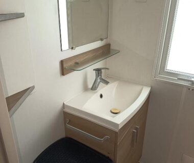 Salle d'eau avec lavabo miroir et fenêtre du mobil-home Les Sables du Midi