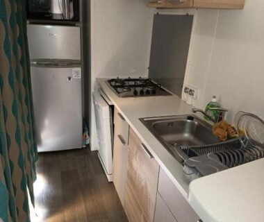 Cuisine compacte avec réfrigérateur et plaque de cuisson dans le mobil-home du camping les sables du midi