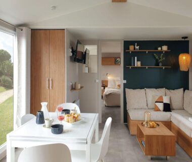 Intérieur lumineux avec coin repas et salon du Mobil home camping luxe 4 étoiles