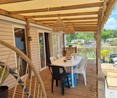 Terrasse couverte en bois avec table et chaises du Mobil home camping luxe 4 étoiles