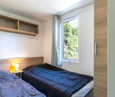 Chambre avec deux lits et fenêtre sur verdure du Mobil home camping siblu