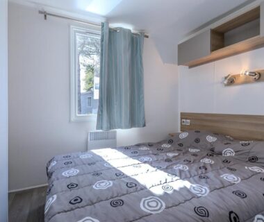 Chambre avec lit double et fenêtre dans le Mobil home camping siblu