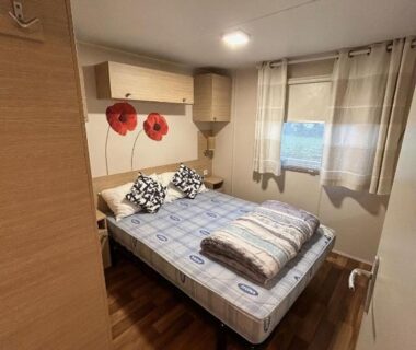 Chambre avec lit double et rideau dans le Mobil home chaleureux finistère sud 2CH 4PERS