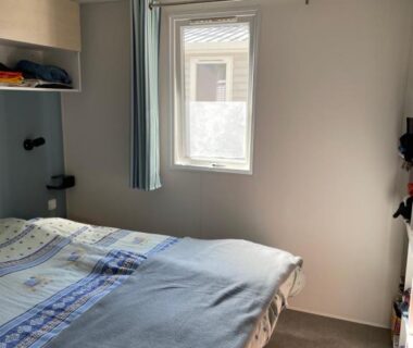 Chambre avec lit double et fenêtre dans le Mobil home charmant