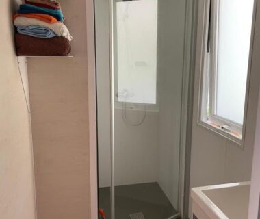 Salle de bain avec cabine de douche et serviettes du Mobil home charmant
