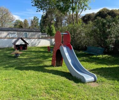 Aire de jeux avec toboggan sur pelouse au Mobil home charmant