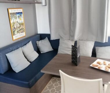 Coin repas avec banquette et table dans le mobil home chez Alain120