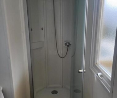 Salle de bain avec cabine de douche dans le mobil-home chez MG