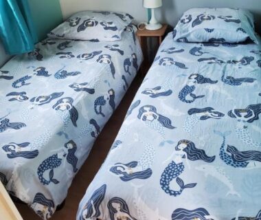 Chambre avec deux lits jumeaux draps motifs sirène dans le Mobil home chez l habitants