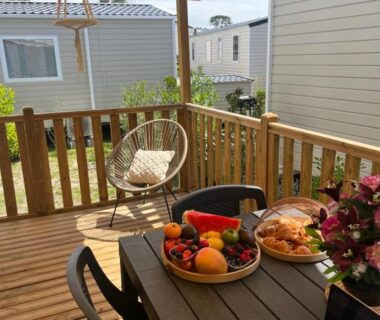 Terrasse en bois avec table et corbeille de fruits du mobil home climatisé