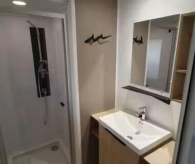 Salle de bain avec cabine de douche lavabo et miroir dans le mobil-home climatisé 6 personnes