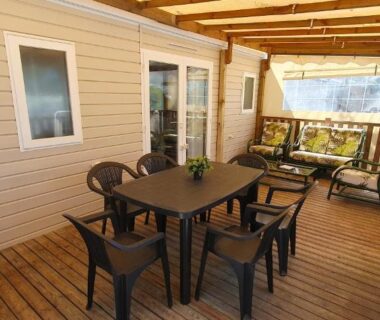 Terrasse couverte avec table et salon extérieur du mobil-home climatisé 6 personnes