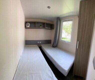 Intérieur chambre avec deux lits simples et armoire dans le mobil home climatisé 6 personnes du camping Tohapi à Boofzheim