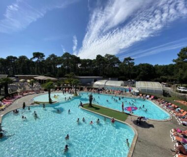 Piscine extérieure avec baigneurs et transats au Mobil home climatisé