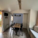 Intérieur avec table à manger et canapé du mobil home climatisé