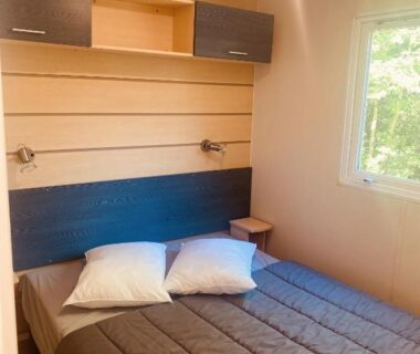 Chambre avec lit double et fenêtre dans le Mobil-home climatisé à 5 min de la mer, charmant