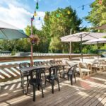 Terrasse en bois avec piscine et parasols du mobil-home climatisé à 5 min de la mer charmant