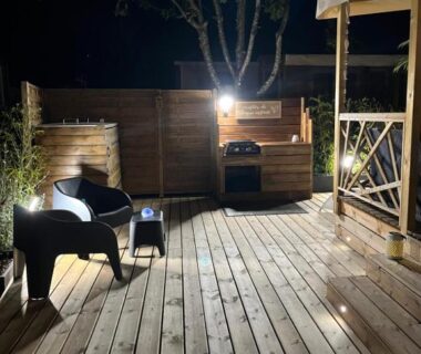 Terrasse en bois éclairée avec chaises et plancha du mobil home climatisé Lège Cap Ferret