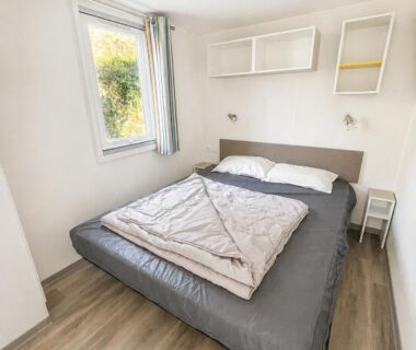 Chambre avec lit double et fenêtre dans le mobil-home climatisé avec piscine chauffée à 10 min de Nice