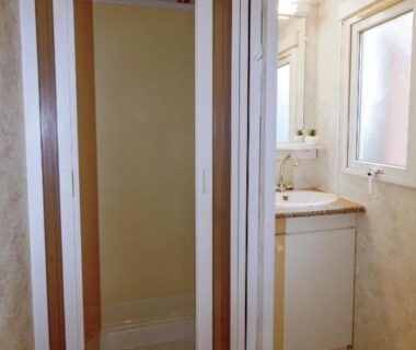 Salle de bain avec cabine de douche et lavabo dans le mobil-home climatisé camping 3 étoiles