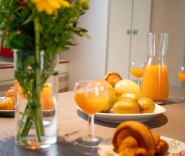 Table de petit déjeuner avec croissant jus d'orange et vase de tournesol dans le mobil-home climatisé