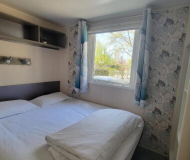 Chambre avec deux lits et fenêtre sur parc du mobil-home climatisé proche lac camping 4 étoiles piscine chauffée