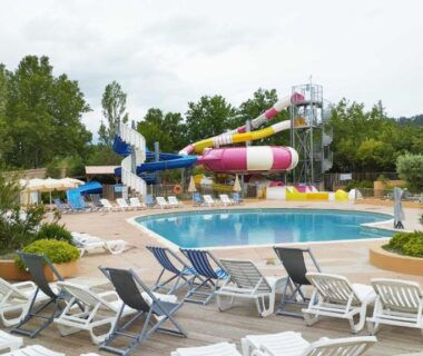 Piscine extérieure avec toboggans et transats au mobil-home climatisé proche lac du camping 4 étoiles piscine chauffée