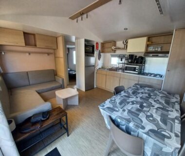 Intérieur avec coin salon et kitchenette dans le Mobil-home climatisé tout confort 3 chambres du camping La Presqu'ile du Barcares