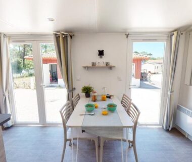 Intérieur avec table à manger et baie vitrée du Mobil-home confort 6 personnes