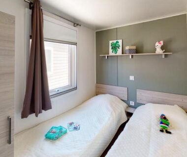 Chambre avec deux lits simples et étagère dans le mobil-home confort 6 personnes