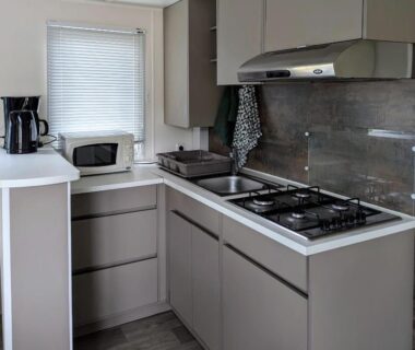 Cuisine équipée avec plaque gaz évier micro-ondes dans le Mobil-home confort Camping 4 étoiles Clim et plage