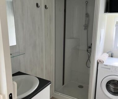Salle de bains avec cabine de douche et lave-linge du mobil home confort XL au camping Homair la Pommeraie