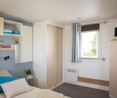 Intérieur du mobil-home avec lit et rangements dans le Mobil-home confortable – 4 pers. – API-1-52-2731