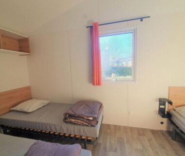 Intérieur chambre lits simples et rideau orange du Mobil-home confortable avec terrasse à Espelette pour 5 personnes API-1-52-1551