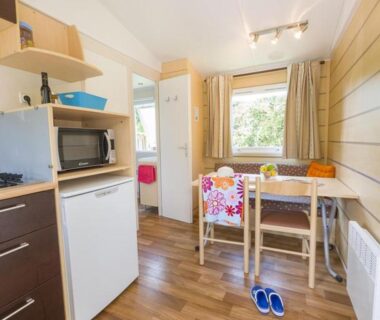 Intérieur avec kitchenette et coin repas du mobil-home confortable avec terrasse à Pezuls API-1-52-683