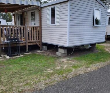 Emplacement herbeux avec terrasse en bois du Mobil home contis lettes 40170