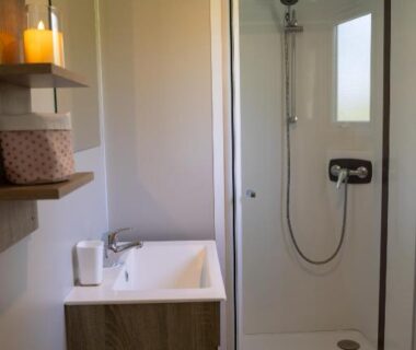 Salle de douche avec lavabo et cabine dans le mobil-home convivial avec vue sur mer Pleubian