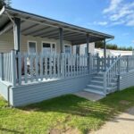 Terrasse couverte en bois avec rambarde et escaliers du Mobil-home cosy 2 chambres Plage Côte d'Opale