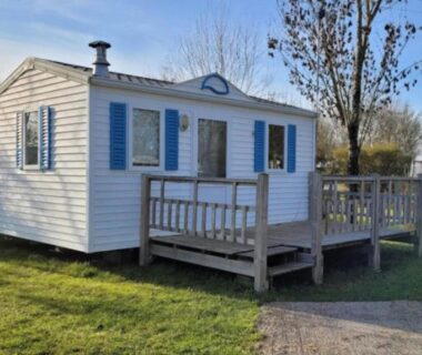 Terrasse en bois devant mobil-home blanc aux volets bleus du Mobil-home cosy avec terrasse à Puyravault API-1-52-1341