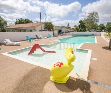 Espace piscine avec pataugeoire toboggan et transats au Mobil-home cosy avec terrasse à Puyravault API-1-52-1341