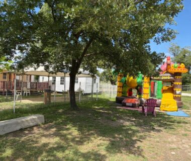 Aire de jeux et mobil-home sous arbres au Camping domaines des iscles