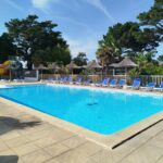 Piscine extérieure avec transats et toboggan au Mobil home cosy dans camping 4 étoiles